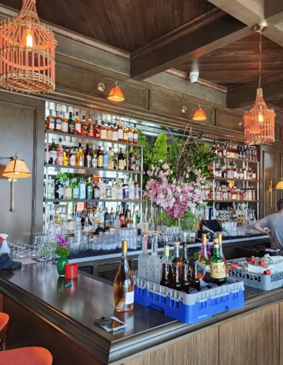 A bar with a lot of bottles and stools.